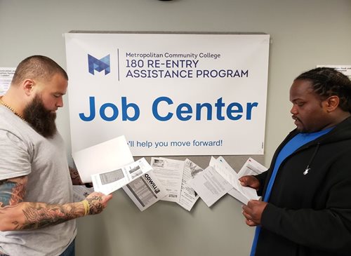 Two mean reviewing paperwork at the Re-Entry Job Center