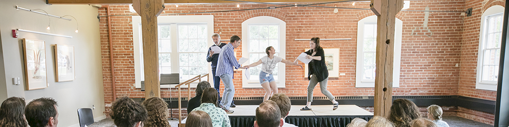 Theatre students act out a scene as their classmates watch
