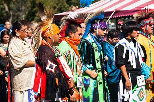 Men in traditional garb stand at attention