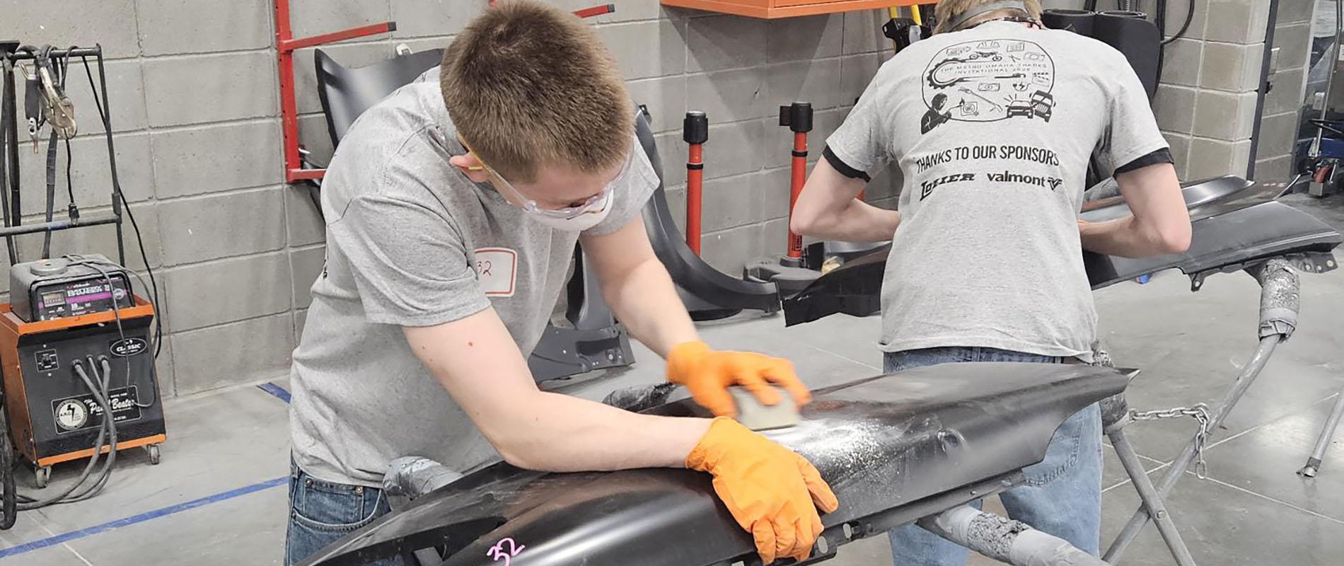 Two students working on a car part