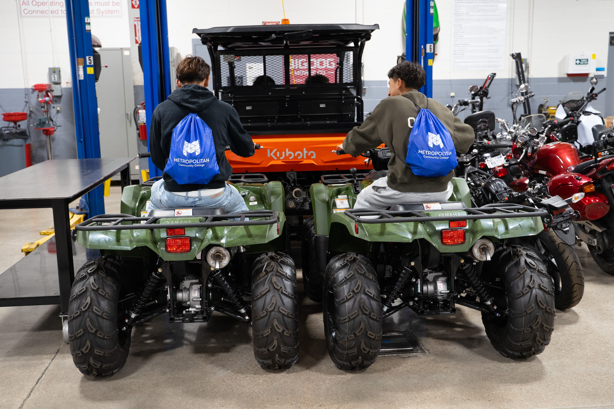 Students sitting on ATVs