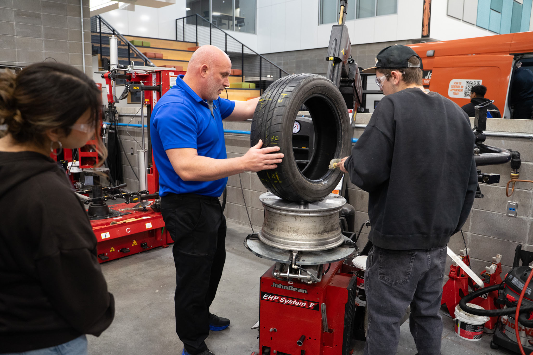 A student and industry professional inspecting a tire