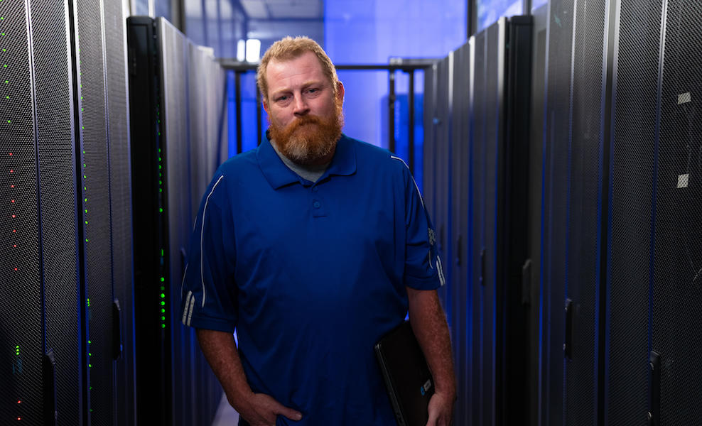 Happy-male-student-standing-in-server-room_sm