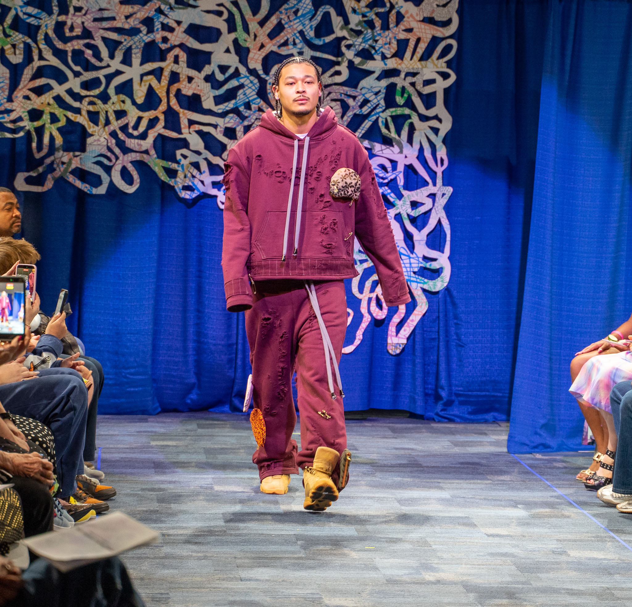 Student model in baggy clothing walking down runway