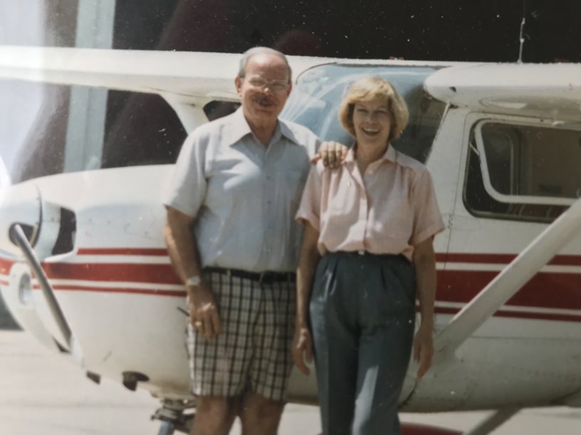 Photo of Alice and Russ DeVoe in front of an airplane