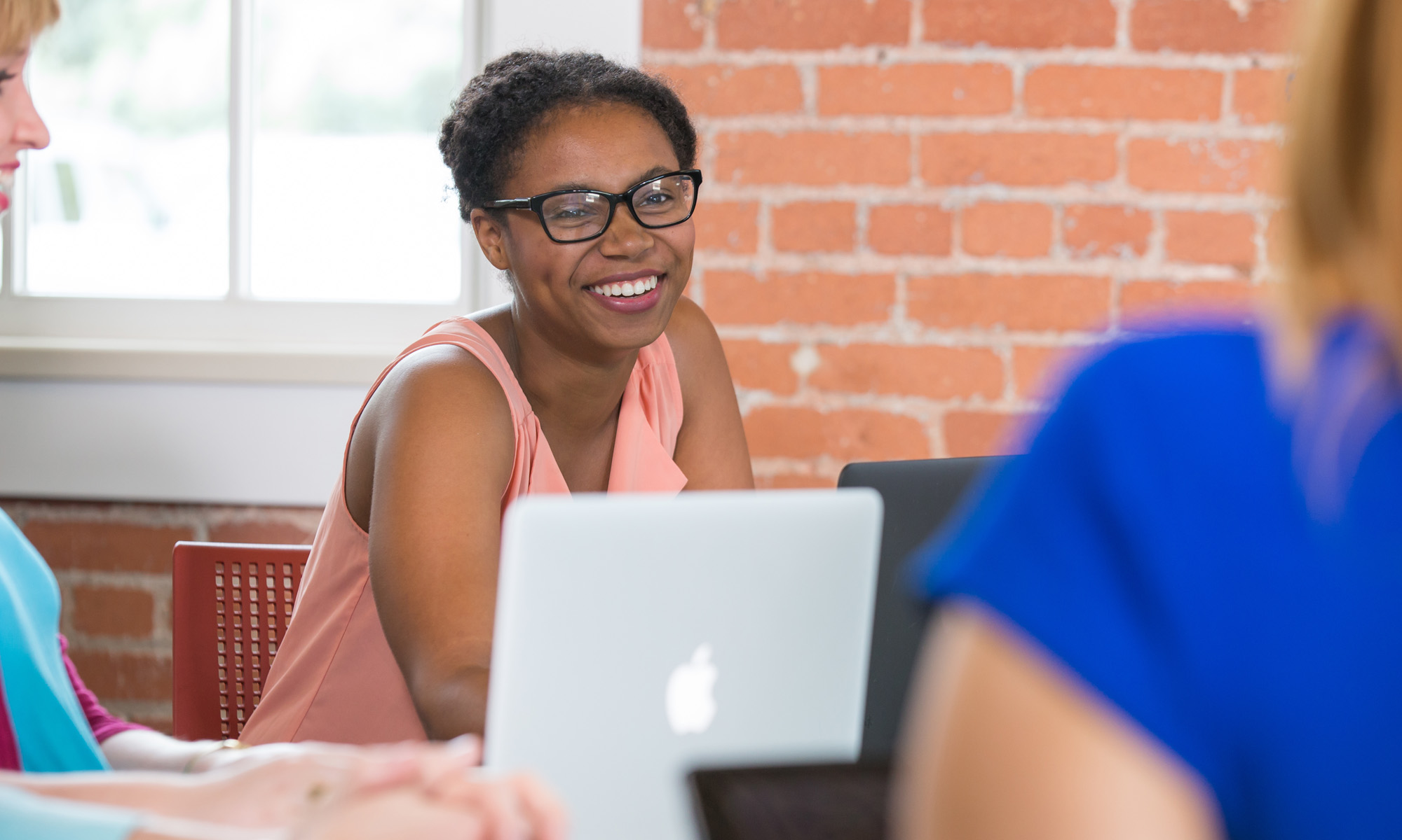 Smiling female student in classroom with other students