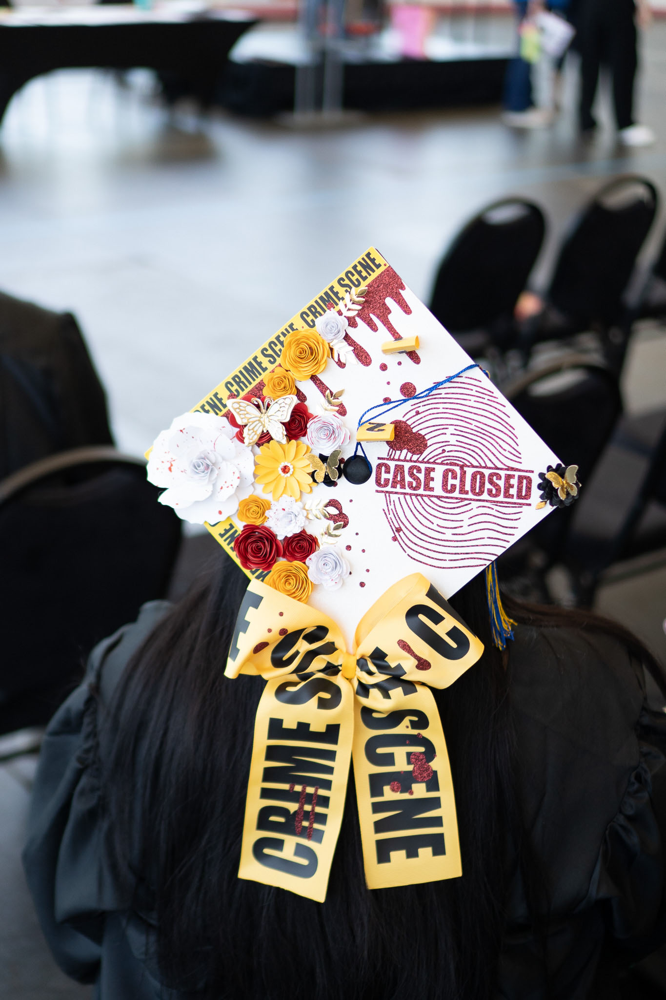 Student wearing crime scene themed graduation cap