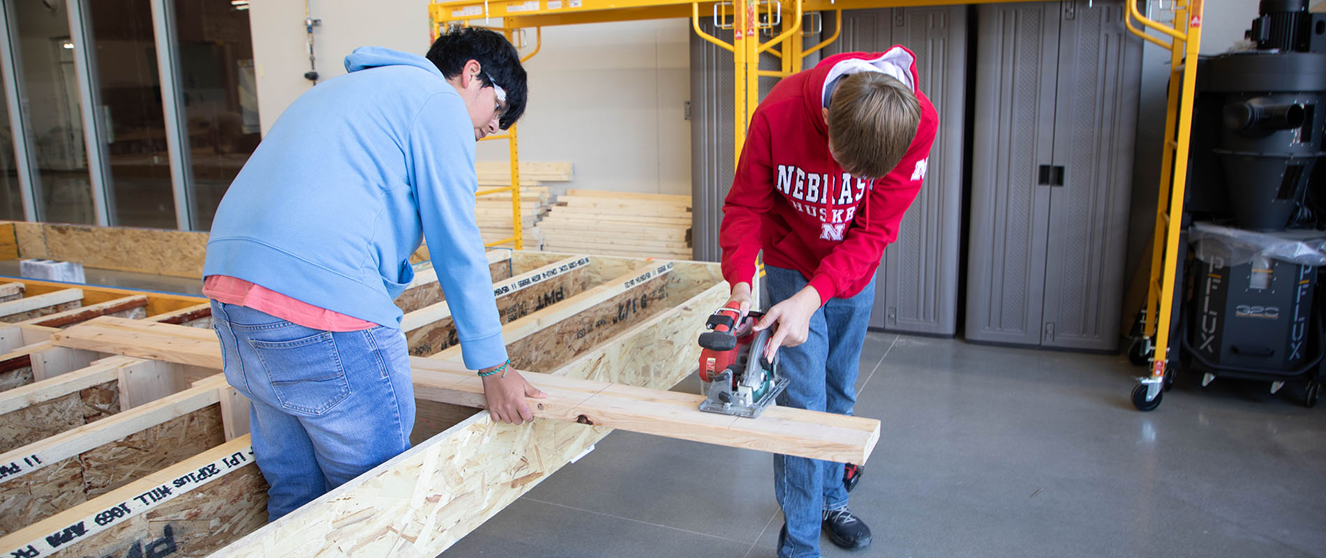 Two students working on the frame of a home
